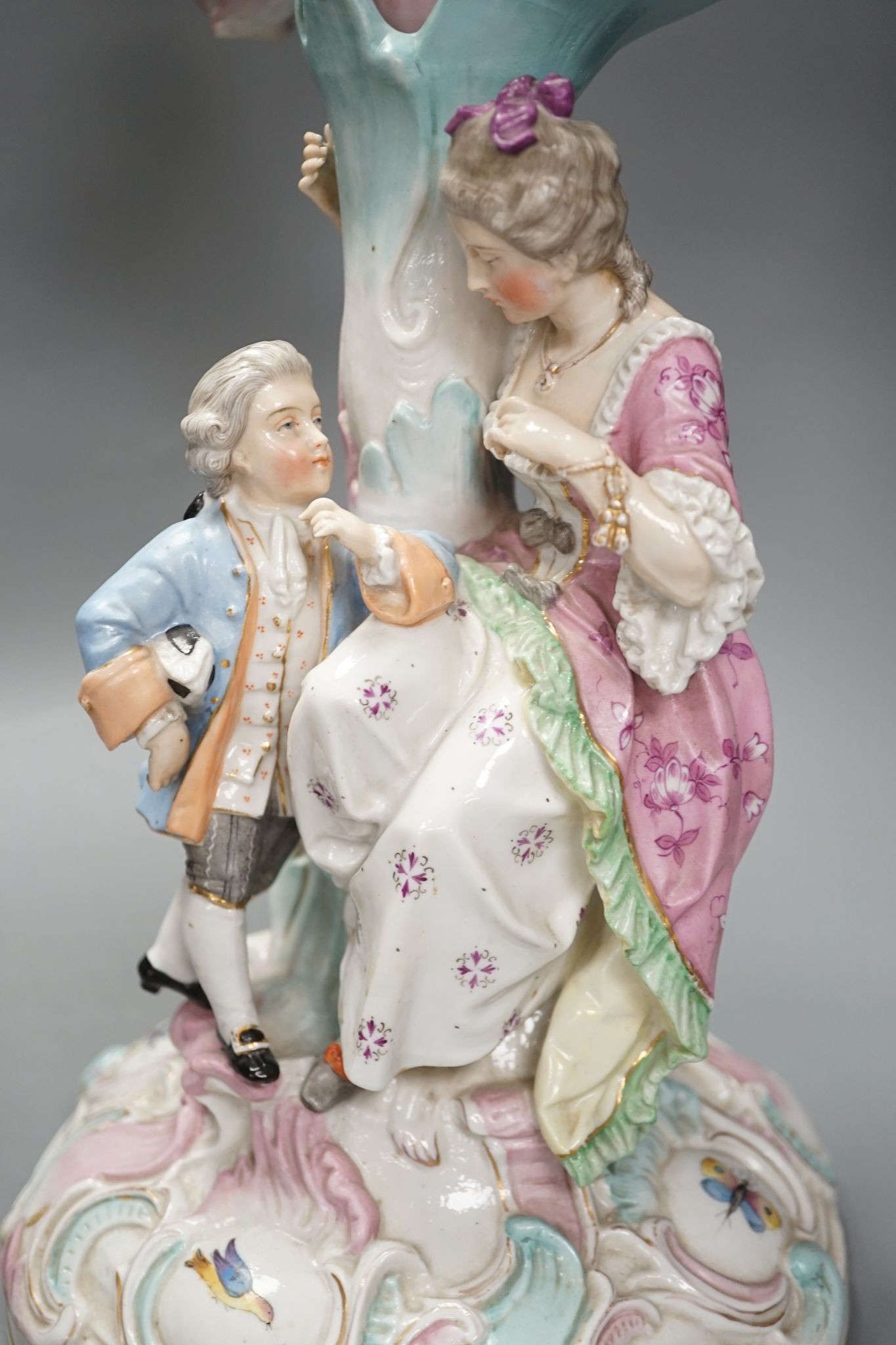 A pair of late 19th century German floral encrusted, figurative porcelain candelabra, 52 cms high.